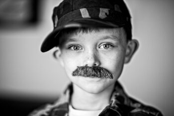 A boy wearing a false moustache.